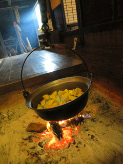 写真：囲炉裏でかぼちゃを煮る作業