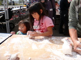 写真：お持ちを丸める女の子と観察する幼児