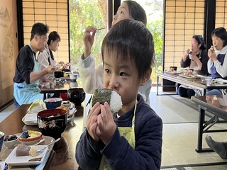 作ったおにぎりをかじる子ども