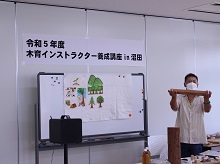 実物の木材を手に取りながら説明をする様子